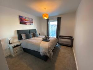 Un dormitorio con una cama grande y una ventana en The Duplex Nairn- Spacious 3 Bedroom with sunny balcony en Nairn