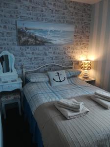 a bedroom with a bed with a anchor pillow on it at Schofield Guest House in Bridlington
