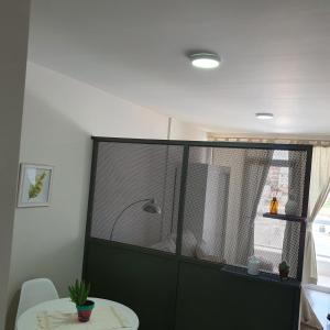 ein Raum mit einer Glastrennwand mit einem Tisch und einem Fenster in der Unterkunft Bonito Departamento a metros del MAR . in Puerto Madryn