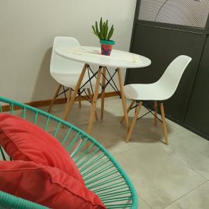 a table with two chairs and a plant on it at Bonito Departamento a metros del MAR . in Puerto Madryn