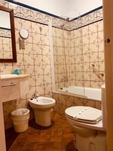 een badkamer met een toilet, een bad en een wastafel bij Hotel Plaza Grande in Zafra