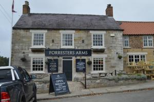 ein vor einem Steingebäude geparkt in der Unterkunft The Forresters Arms Kilburn in Kilburn