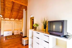 un soggiorno con TV su un comò bianco di Precioso apartamento reformado en Liencres a Liencres