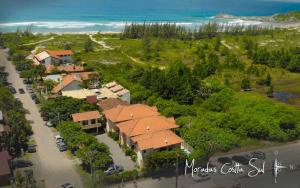arial view of a house with a road and a beach at Moradas Costta Sul in Garopaba