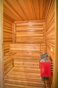 eine Holzsauna mit einem roten Kühler darin in der Unterkunft Mountain Dream 3 Bed, Sauna, & Stunning Views in Mill Spring