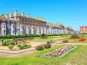a large building with a garden in front of it at Moray Beachside Apartments in Lowestoft