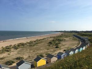 a row of colorful beach huts on a beach at Moray Beachside Apartments in Lowestoft