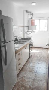 uma cozinha com um frigorífico e um lavatório. em Departamento con COCHERA - Santa Fe em Santa Fé