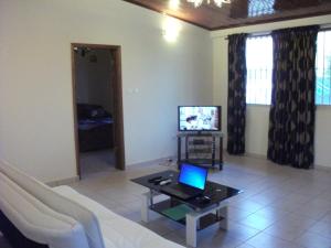 - un salon avec un canapé et un ordinateur portable sur une table dans l'établissement Residence Japoma, à Douala
