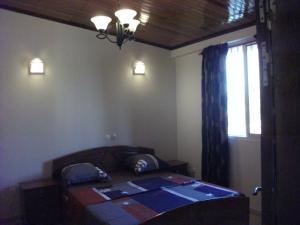 - une chambre avec un lit, une fenêtre et une fenêtre dans l'établissement Residence Japoma, à Douala