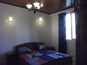 a bedroom with a bed and a window and a window at Residence Japoma in Douala