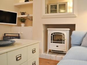 a living room with a fireplace with a tv at Starboard Light in Lymington