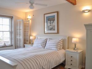 a bedroom with a white bed with two night stands at Starboard Light in Lymington