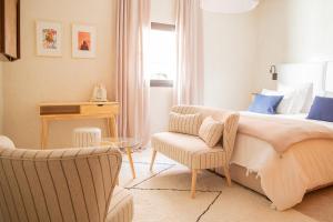 - une chambre avec un lit et une chaise dans l'établissement Le Pavillon de la Kasbah & SPA Marrakech, à Marrakech