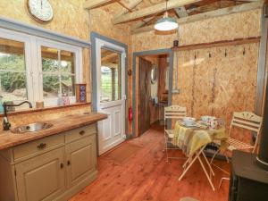 a kitchen with a table and a dining room at Bramley Orchard Glamping in Retford