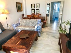 een woonkamer met een bank en een tafel bij GATU PREMIUM Vista Infinita 1ªlinea mar WIFI, AIRE ACC in Cádiz