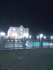 Microtel Inn & Suites by Wyndham Camp Lejeune/Jacksonville في جاكسونفيل: حاجز امام مبنى في الليل