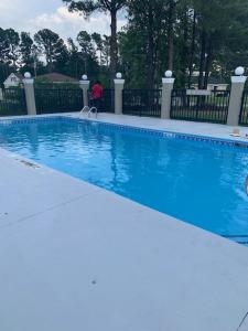 a large blue swimming pool in a yard at Microtel Inn & Suites by Wyndham Camp Lejeune/Jacksonville in Jacksonville