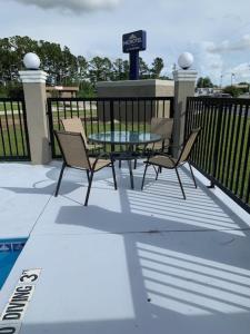 Microtel Inn & Suites by Wyndham Camp Lejeune/Jacksonville في جاكسونفيل: فناء مع طاولة وكراسي وسياج