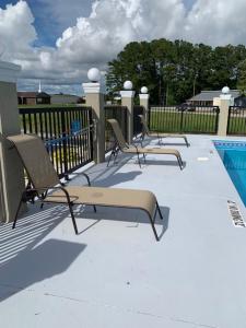 eine Gruppe von Stühlen neben einem Pool in der Unterkunft Microtel Inn & Suites by Wyndham Camp Lejeune/Jacksonville in Jacksonville