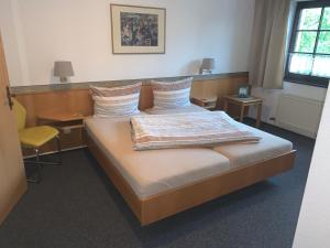 a bedroom with a bed and a desk and a chair at Hotel am Neumarkt in Zeitz