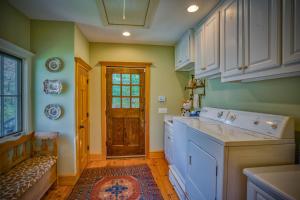 eine Küche mit weißen Schränken und einer Tür in der Unterkunft Mountain Dream 3 Bed, Sauna, & Stunning Views in Mill Spring + 31 Fotos