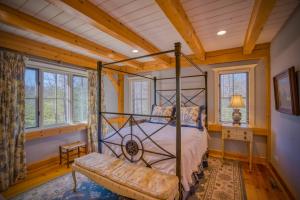 ein Schlafzimmer mit einem Bett und einer Bank in einem Zimmer in der Unterkunft Mountain Dream 3 Bed, Sauna, & Stunning Views in Mill Spring