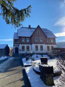 ein großes Haus mit Schnee auf dem Boden in der Unterkunft Villa Borchert in Wernigerode
