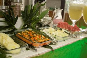 Caruaru Pallace Hotel في كاروارو: بوفيه مع عدة أطباق من الطعام على طاولة