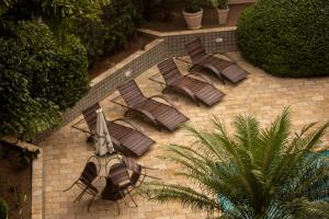 een groep bruine ligstoelen op een bakstenen patio bij Caruaru Pallace Hotel in Caruaru