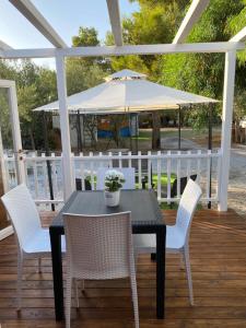 een zwarte tafel en stoelen met een witte paraplu bij Camping roccella mare in Campofelice di Roccella