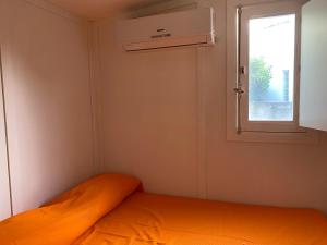 a small bedroom with a bed and a window at Camping roccella mare in Campofelice di Roccella