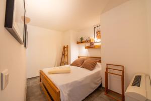 een kleine slaapkamer met een bed en een stoel bij Beautiful Apartment In The Heart Of Saint Tropez in Saint-Tropez