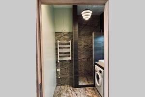 een badkamer met wastafel en wasmachine bij Botanical Manor Apartment in Kaunas +52 foto's
