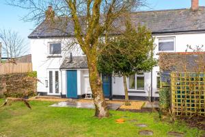 ein weißes Haus mit einem Baum im Hof in der Unterkunft Finest Retreats - Court Cottage in East Buckland