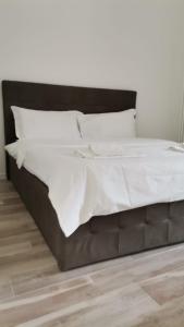 a bed with white sheets and pillows in a bedroom at Battistelli Apartments in Bologna
