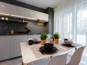 a dining room with a table and chairs and a kitchen at VacationClub – Unieście-Szafirowa Mierzeja 9 in Mielno