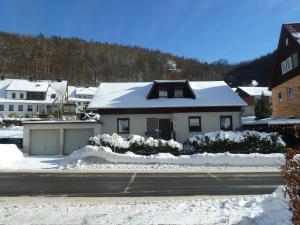 Una casa blanca con nieve encima. en Ferienwohnung Gerken, en Wieda