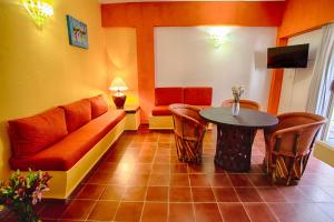a living room with a couch and a table at Suites Plaza del Rio - Family Hotel Malec&oacute;n Centro in Puerto Vallarta