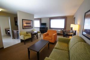 a living room with a couch and chairs in a hotel room at Creekside Hotel & Suites in Canyonville