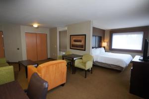 um quarto de hotel com uma cama, uma secretária e cadeiras em Creekside Hotel & Suites em Canyonville