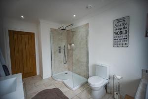 een badkamer met een douche en een toilet. bij Langley Cottage with patio, spacious rooms - part of Langley Serviced Apartments several properties in Wick in Wick