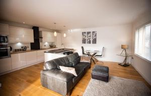 een woonkamer met een bank en een keuken bij Langley Cottage with patio, spacious rooms - part of Langley Serviced Apartments several properties in Wick in Wick +5 foto's
