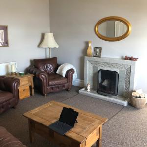 a living room with a fireplace and a laptop on a coffee table at The View in Grange Over Sands