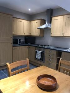 a kitchen with a wooden table with a wooden bowl on it at The View in Grange Over Sands +3 photos
