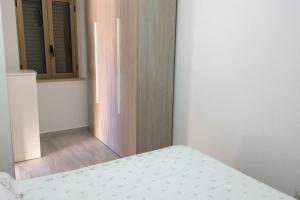 ein weißes Zimmer mit einem Bett und einer Tür in der Unterkunft Sunsetsunrisecilento in Caprioli