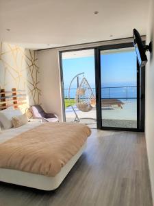 a bedroom with a bed and a view of the ocean at Villa Brava Atlântico in Ribeira Brava