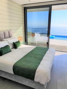 um quarto com uma cama grande e vista para o oceano em Villa Brava Atlântico em Ribeira Brava