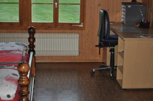 sypialnia z biurkiem, łóżkiem i krzesłem w obiekcie Ruhe pur w mieście Aeschi bei Spiez