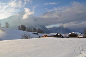 ein schneebedeckter Hügel mit Häusern und Bergen im Hintergrund in der Unterkunft Ruhe pur in Aeschi bei Spiez + 5 Fotos